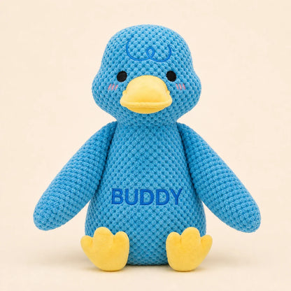 Personalized blue duck plush dog toy with Buddy name on warm studio background
